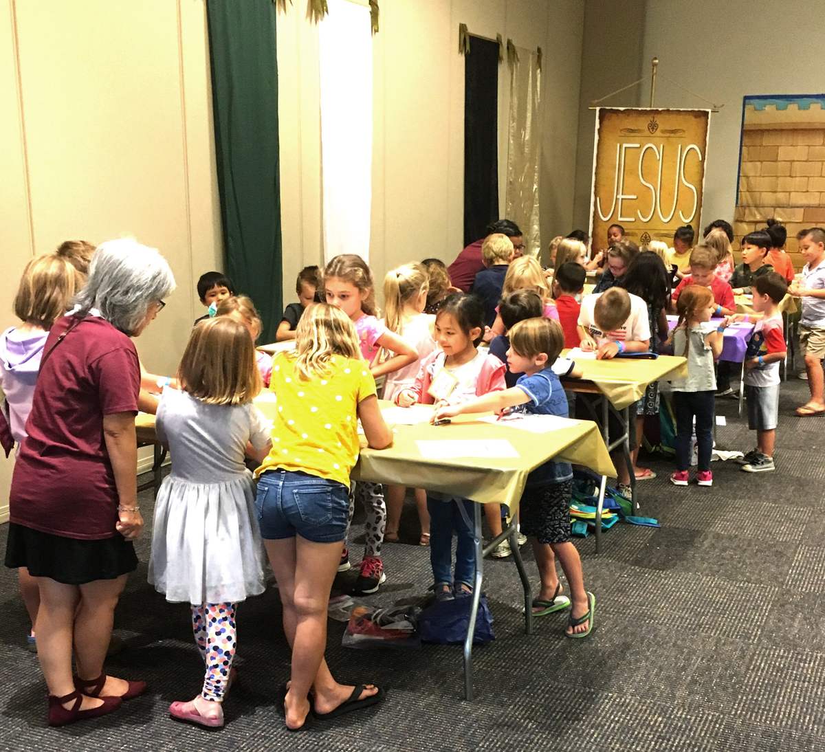 Children working on crafts at long tables during a Good News Club