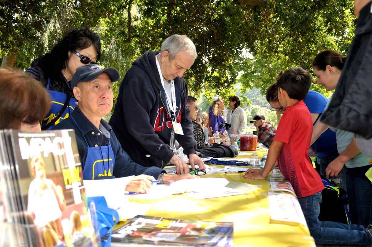 Volunteers sharing the Gospel with children at an outdoor CEF booth